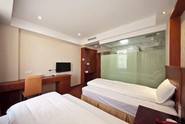 A hotel room with two beds, a desk, a chair, a television, and a glass partition. - Meiguiyuan Business Hotel (Yongchun)