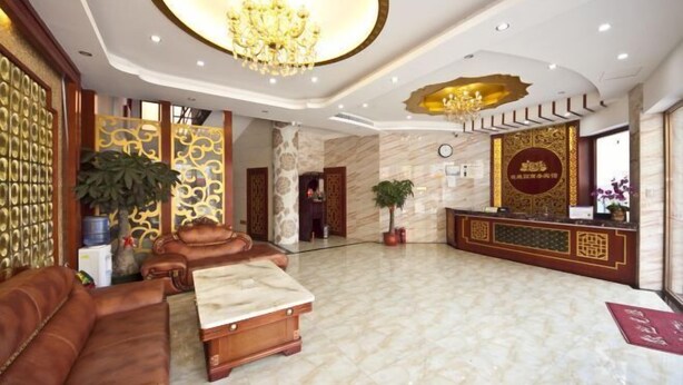 A spacious lobby with a marble floor, leather seating, a reception desk, and a chandelier. - Meiguiyuan Business Hotel (Yongchun)