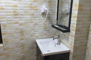 A bathroom with a white sink, a mirror, and a towel rack. - Meiguiyuan Business Hotel (Yongchun)