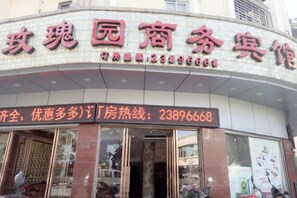 A hotel entrance with a signboard displaying the name and contact number. - Meiguiyuan Business Hotel (Yongchun)