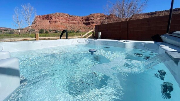 A hot tub with a clear view of red rock formations in the background.