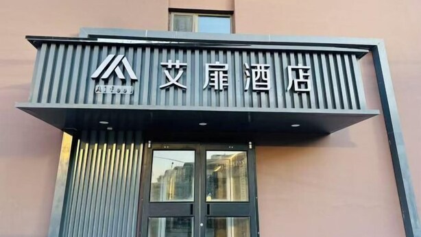 A hotel sign with Chinese characters and a modern architectural design.