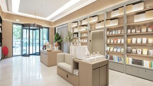 A modern interior with a reception desk, seating area, and bookshelves. - Ji Hotel (government Shop, Ouhai District, Wenzhou (Wenzhou)