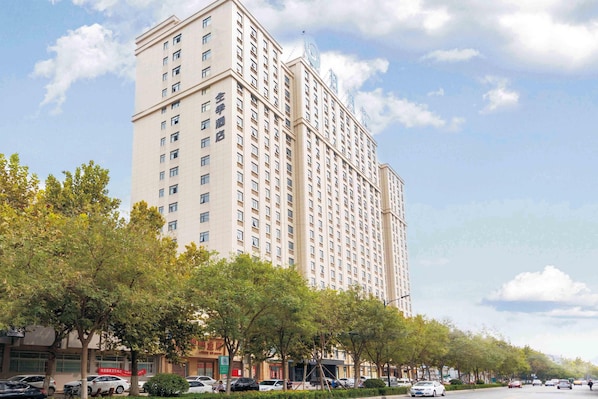 A high-rise hotel with multiple floors, a prominent entrance, and a clear view of the surrounding urban environment. - Ji Hotel (Kaifeng)