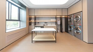 A modern kitchen with built-in appliances, a central island, and a large window. - Ji Hotel (Kaifeng)