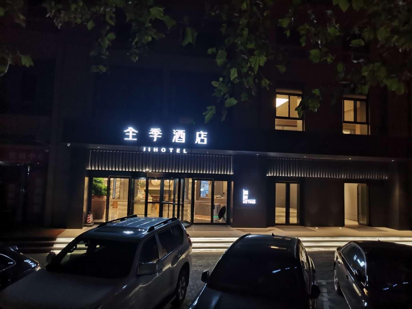 A hotel entrance with a sign reading "JI HOTEL" and a visible entrance door.