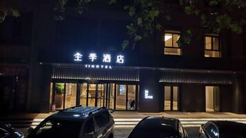 A hotel entrance with a sign reading "JI HOTEL" and a visible entrance door.