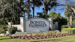Schild für Bonita Fairways mit gepflegtem Rasen und tropischen Pflanzen.