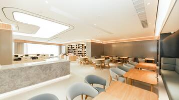 Een modern interieur met een centraal gelegen balie, zithoek en boekenkasten.