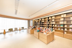 A modern interior with a central reception desk, seating area, and bookshelves. - Ji Hotel (Xi'an)