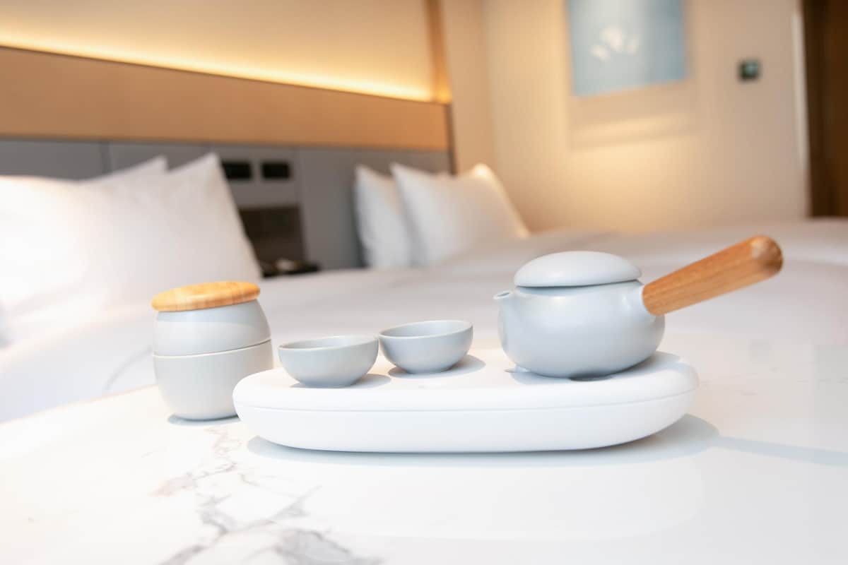 A neatly arranged tea set on a marble surface in a hotel room.