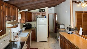 Una cocina con armarios de madera, un refrigerador, un microondas y una estufa.