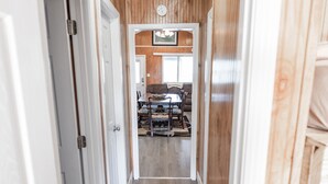 Un couloir avec des lambris en bois, un tapis et un luminaire au plafond.