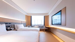 A hotel room with two beds, a desk, a chair, and a large window. - Ji Hotel Nantong Motor East Station (Nantong)