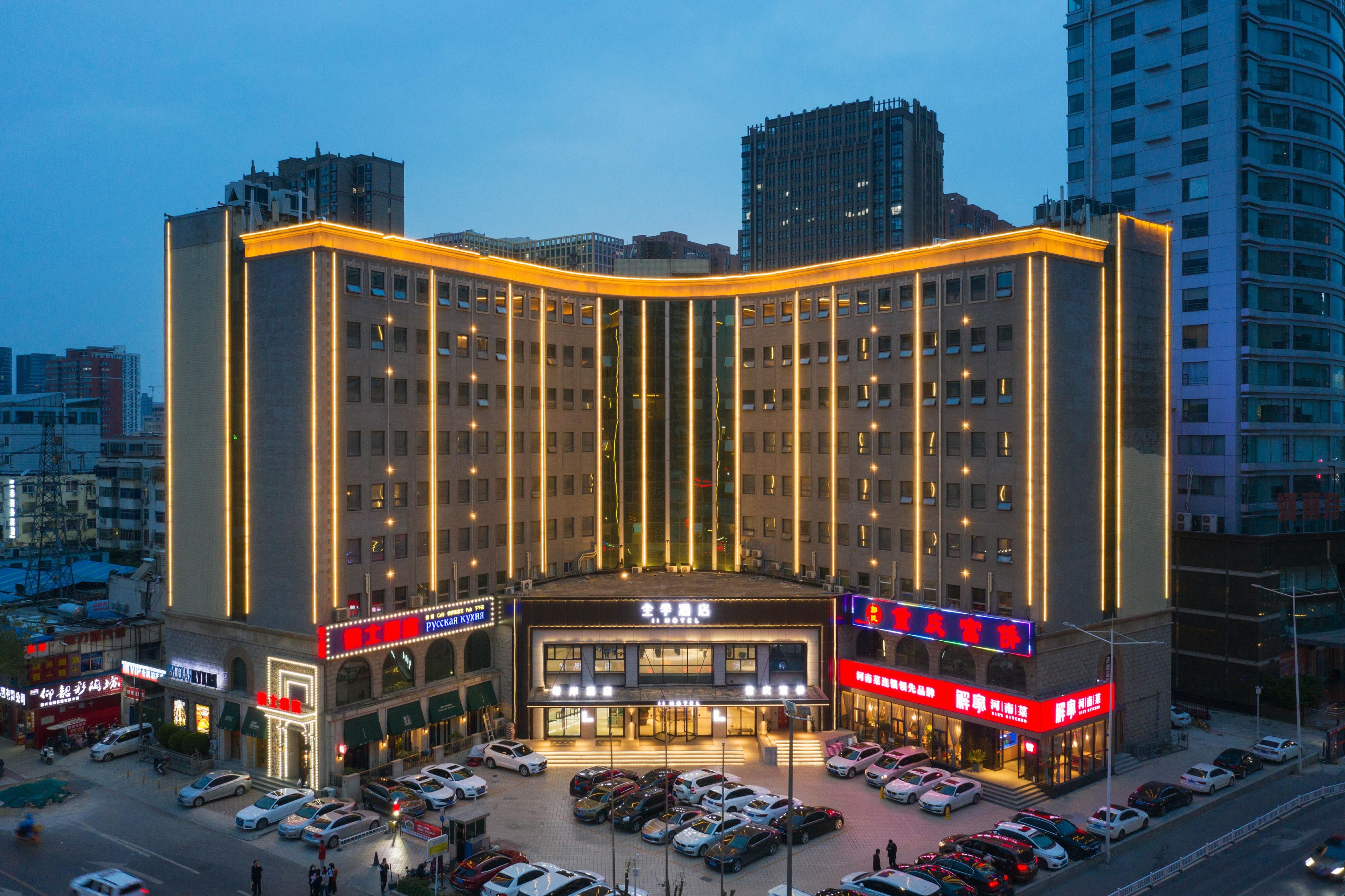 Un hôtel à plusieurs étages, doté d’une entrée imposante, de nombreux espaces de stationnement et entouré d’immeubles de grande hauteur.
