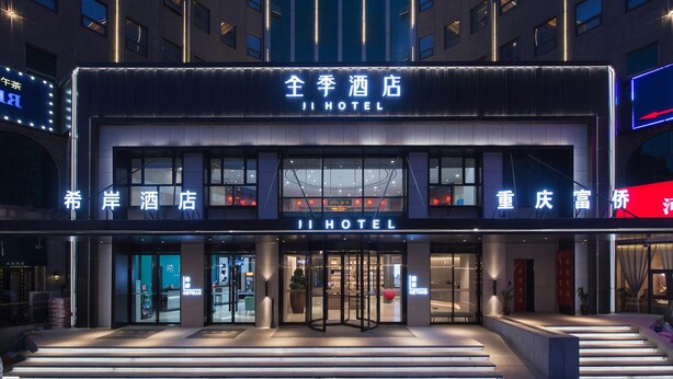 A hotel with a modern facade, large glass windows, and a prominent entrance with a revolving door. - Ji Hotel (future Road Store, Convention & Exhibiti (Zhengzhou)