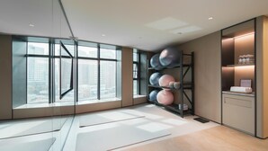 A modern room with large windows, a yoga mat, and a shelf with exercise balls. - Ji Hotel (future Road Store, Convention & Exhibiti (Zhengzhou)