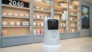 A self-service kiosk in a bookstore with shelves of books behind it.