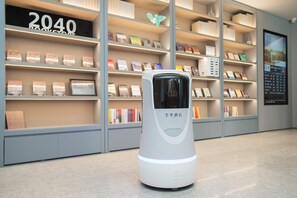 A self-service kiosk in a bookstore with shelves of books behind it. - Ji Hotel (future Road Store, Convention & Exhibiti (Zhengzhou)