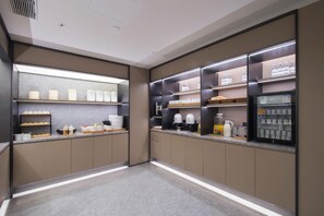 Una cocina moderna con electrodomésticos integrados, una estación de café y un refrigerador expositor.