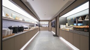 A modern kitchen with a long counter, equipped with various appliances and food items. - Ji Hotel (future Road Store, Convention & Exhibiti (Zhengzhou)