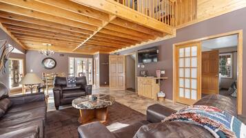 Télévision à écran plat, cheminée, baby-foot, livres