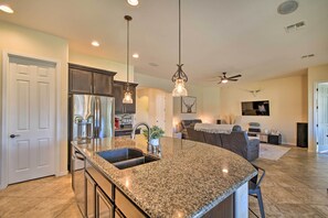 Enjoy cooking in this well-equipped kitchen with a refrigerator, sink, and dining area.