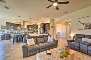 Relax in this stylish living area with a large sofa, coffee table, and dining bar, perfect for social gatherings.