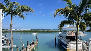 A marina with boats docked, palm trees, and a clear blue sky. - Villa 5087 on Duck Key Boat Slip Available - 2BD 2.5BA (Duck Key)