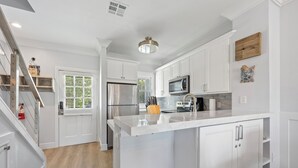 A modern kitchen with white cabinetry, stainless steel appliances, and a central island. - Villa 5087 on Duck Key Boat Slip Available - 2BD 2.5BA (Duck Key)