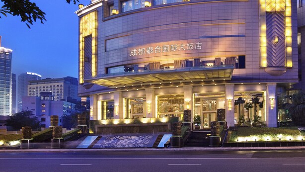 A high-rise hotel with a modern design, featuring illuminated vertical lines and a well-lit entrance. - Chengdu Taihe International Hotel (Chengdu)