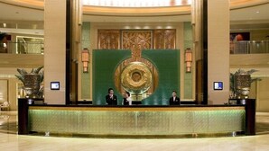A reception area with a large decorative wall, a reception desk, and two attendants. - Chengdu Taihe International Hotel (Chengdu)