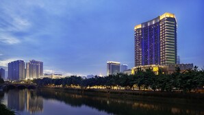 A high-rise hotel with a modern design, situated beside a calm river with a bridge in the foreground. - Chengdu Taihe International Hotel (Chengdu)