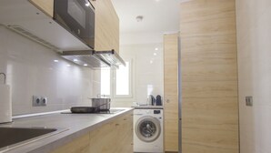 Una cocina moderna con lavadora integrada, un fregadero y una estufa.