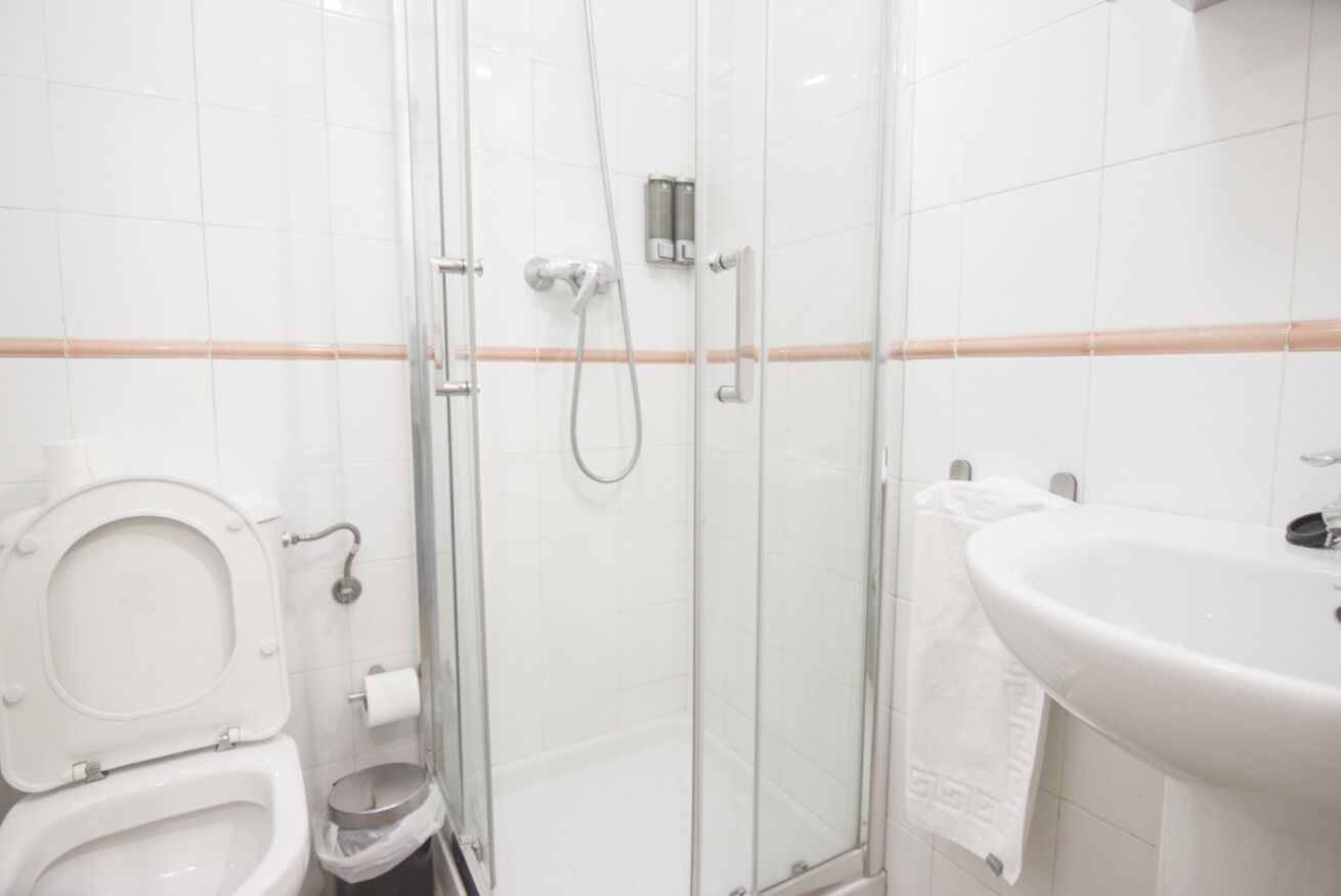 A bathroom with a toilet, a glass-enclosed shower, and a sink.