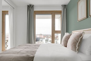 Enjoy a city view from the large bed in this stylish room.