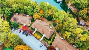 Vue aérienne d’un quartier résidentiel avec des maisons, un parking et une étendue d’eau.