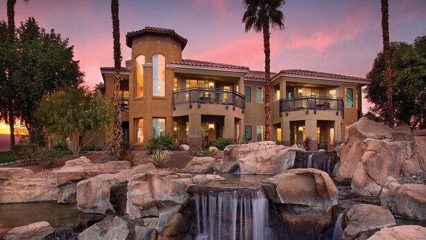 A multi-story hotel with a waterfall feature in the courtyard.