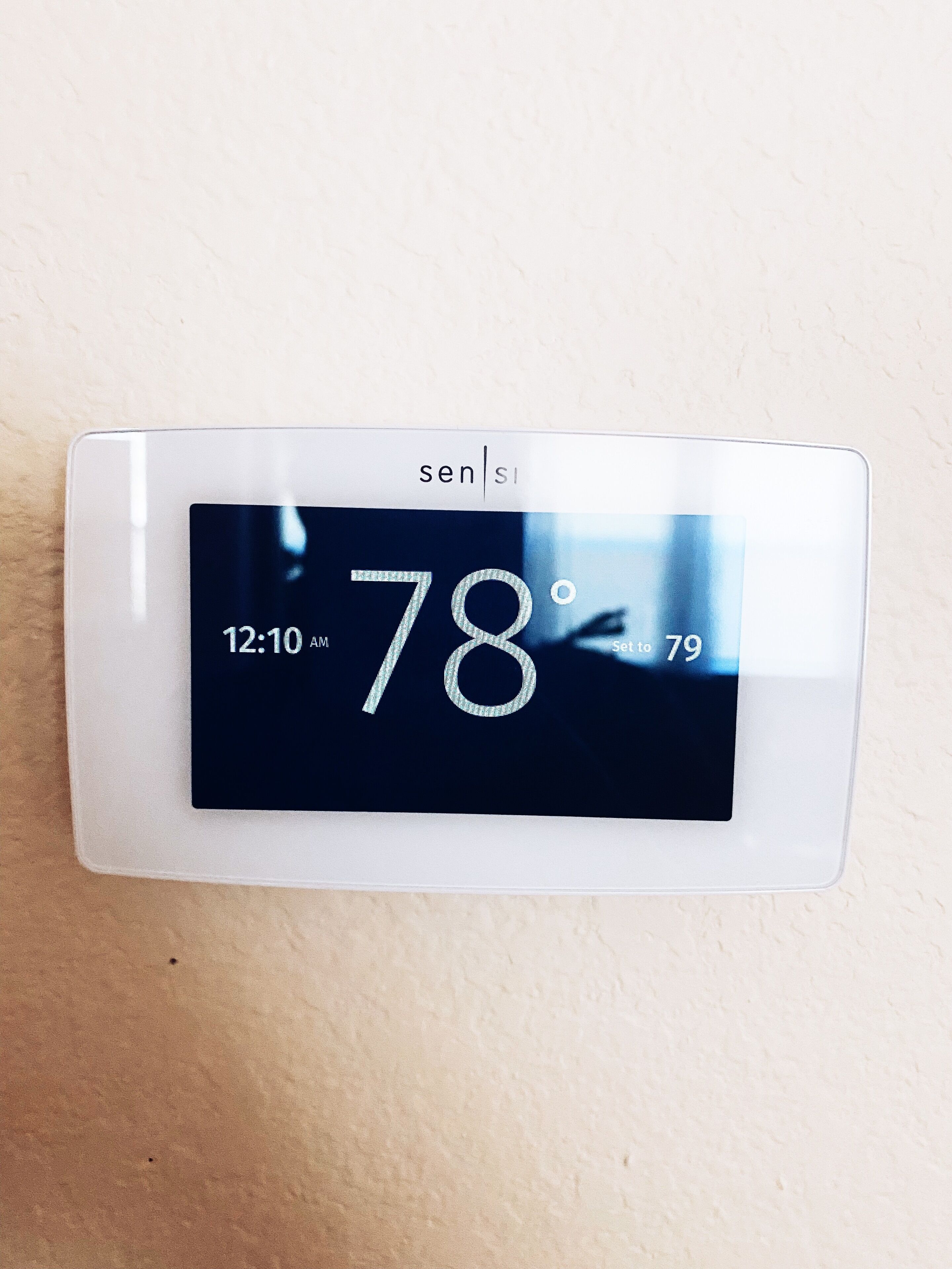 Termostato mostrando una temperatura de 26 grados, ajustado a 27, con la hora de 00:10.