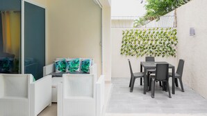 A patio area with a pool, white wicker furniture, and a table with chairs. - Mansión Versatil with a beautiful private pool 🏊‍♀️ 5 min from movies/groceries  (La Romana)