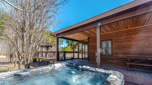 A wooden cabin with a hot tub and outdoor seating area. - Secluded Lodge 8acres Hot Tub, Pingpong kayaks! (Sampson County)