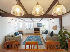 A living room with a wooden floor, two sofas, a coffee table, and three hanging lamps. - Baytree Cottage, Walberton -  a cottage that sleeps 6 guests  in 3 bedrooms (Arundel)