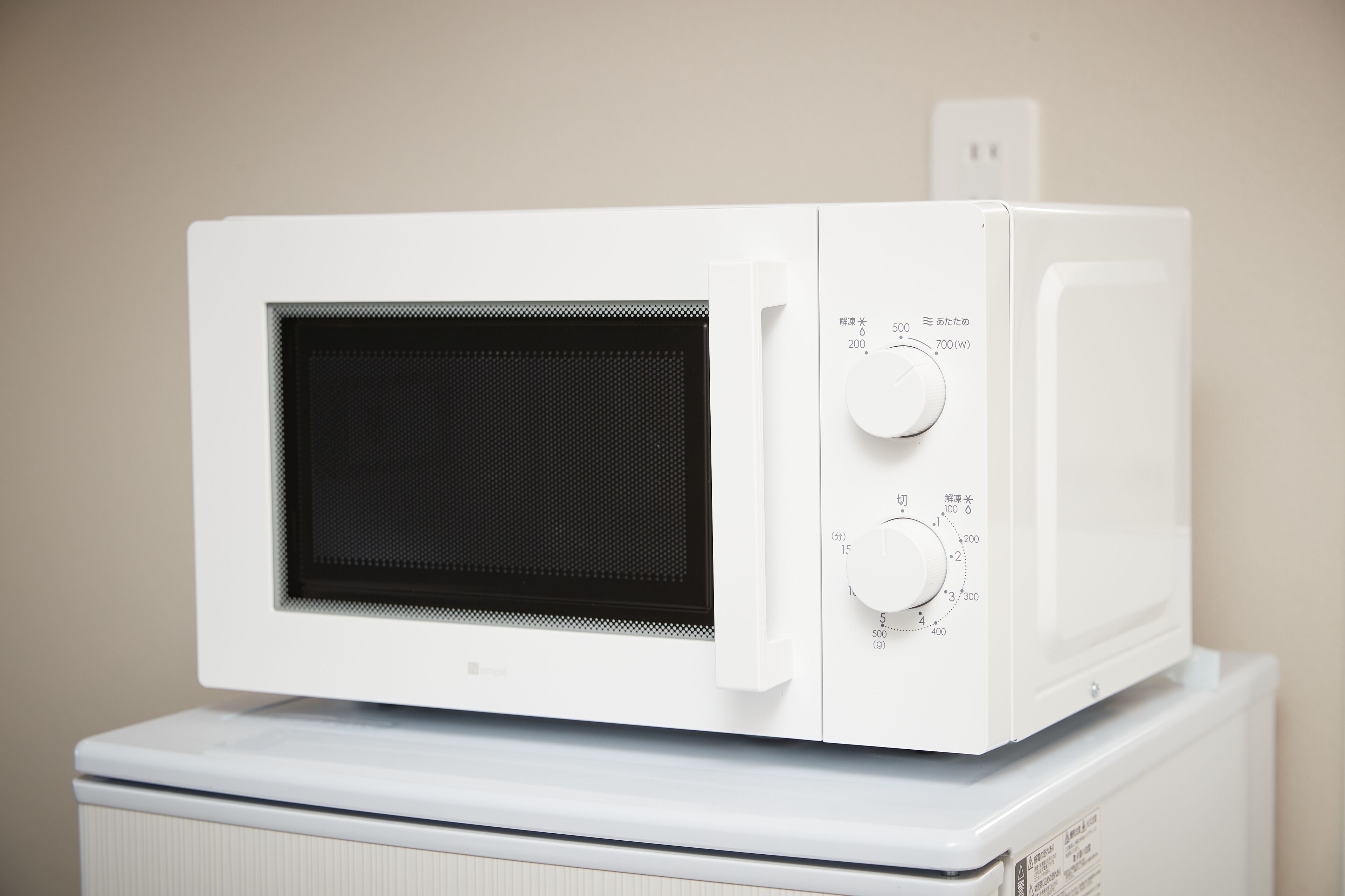 Un forno a microonde bianco su un elettrodomestico bianco.