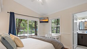 Quarto com uma cama grande, uma escrivaninha e vista para o exterior.