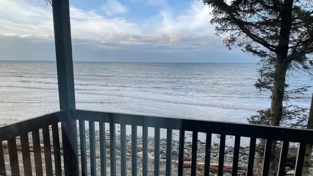 Un balcón con vista al mar y la costa rocosa.
