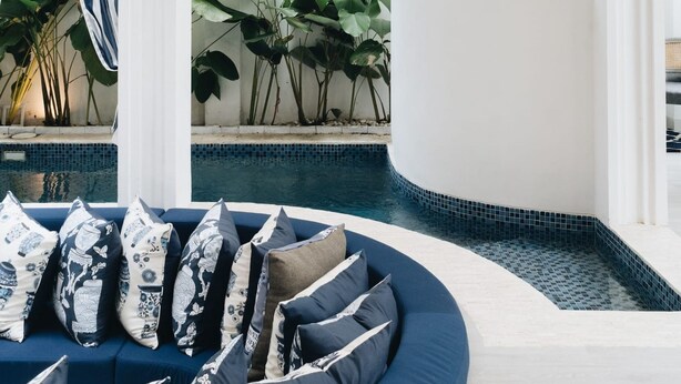 A modern interior with a curved seating area, a spiral staircase, and a pool. - OriVista Stylish 3BR Villa Muzo in Seminyak, Pool, Wifi, Beach (Seminyak)