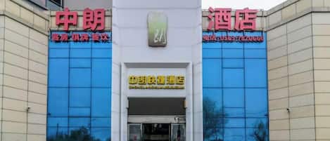 A hotel entrance with a sign indicating a 'Fast Food Restaurant' and a contact number.