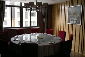 A conference room with a round table, red chairs, and a painting on the wall. - Zhonglang Express Hotel (Langxi)