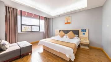 Habitación de hotel con cama, mesita de noche, silla, ventana y luz en el techo.