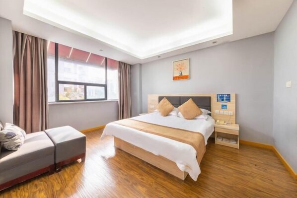 A hotel room with a bed, a bedside table, a chair, a window, and a ceiling light.